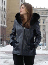 Load image into Gallery viewer, Woman wearing black lamb leather jacket with fox trimmed detachable hood and braided trim, perfect for winter fashion.