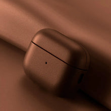 Cargar imagen en el visor de la galería, Genuine leather AirPods case in brown, showcasing elegant protection and style on a leather background.