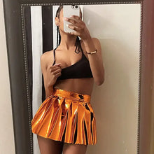 Cargar imagen en el visor de la galería, Woman wearing a metallic pleated mini skirt and black top, taking a mirror selfie.