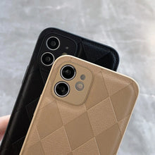 Cargar imagen en el visor de la galería, Two smartphones with black and beige retro vegan leather cases featuring a stylish checkered pattern, held in hand.