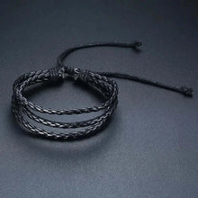 Cargar imagen en el visor de la galería, Stylish black braided leather wrap bracelet on a dark background, showcasing intricate design and quality craftsmanship.