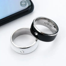 Cargar imagen en el visor de la galería, NFC smart rings in black and silver next to a smartphone, showcasing waterproof technology and seamless connectivity.