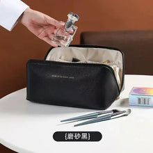 Cargar imagen en el visor de la galería, High-Capacity Leather Cosmetic Organizer with makeup brushes and perfume on a white table.