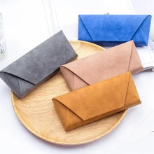 Cargar imagen en el visor de la galería, Fashion PU Leather Sunglasses Case in four colors on wooden plate, showcasing stylish and practical design for eyewear protection.