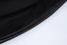 Load image into Gallery viewer, Close-up of black faux leather ruched mini dress fabric showing texture and stitching details.