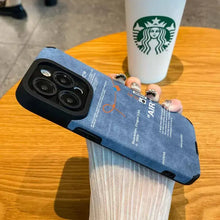 Cargar imagen en el visor de la galería, Luxury Leather Sneaker Phone Case on table next to Starbucks cup, showcasing sleek design and soft suede leather label.