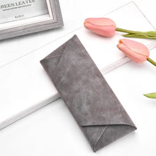 Cargar imagen en el visor de la galería, Gray PU leather sunglasses case on white surface, surrounded by pink tulips, ideal for eyewear protection and style.