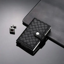 Load image into Gallery viewer, Black leather RFID cardholder on black surface with cufflinks, combining style and security for modern card protection.