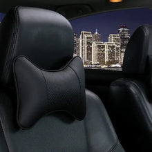 Cargar imagen en el visor de la galería, PU leather car neck pillow on seat, night city backdrop, offers head pain relief and comfort. Stylish vegan leather, imported quality.