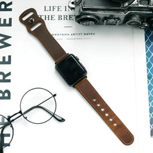 Cargar imagen en el visor de la galería, Elegant leather band watch displayed on a magazine with a vintage camera and glasses nearby, showcasing timeless sophistication.