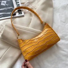 Cargar imagen en el visor de la galería, Yellow vegan leather shoulder bag with crocodile pattern on white cloth background.