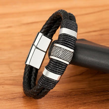 Cargar imagen en el visor de la galería, Woven leather rope and stainless steel men's bracelet on wooden surface, showcasing high-quality craftsmanship.