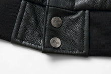 Load image into Gallery viewer, Close-up of REED Men's Premium Leather Aviator Bomber Jacket, showing black leather texture and branded metal buttons.