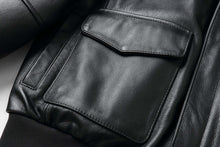 Load image into Gallery viewer, Close-up of REED Men's Premium Leather Aviator Bomber Jacket pocket, showcasing soft durable imported leather and classic design features.