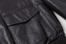 Load image into Gallery viewer, Close-up of REED Men's Premium Leather Aviator Bomber Jacket showing front envelope pocket and soft leather texture.