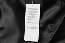 Cargar imagen en el visor de la galería, Care label inside black jacket with multilingual washing and care instructions.