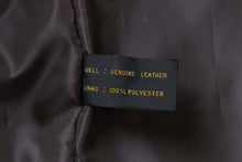Load image into Gallery viewer, Close-up of a Genuine Leather and 100% Polyester label inside a REED men's lambskin jacket.