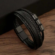 Load image into Gallery viewer, Classic men's leather bracelet with sleek black design, braided texture, and metal accents on a wooden background.
