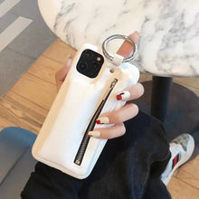 Cargar imagen en el visor de la galería, Person holding a white luxury zipper PU leather wallet case for iPhone, featuring a zipper closure and ring holder, on a marble table.