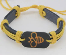 Cargar imagen en el visor de la galería, Yellow and navy leather bracelet with engraved bee motif and adjustable cord.