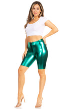 Cargar imagen en el visor de la galería, Model wearing shiny metallic green bike shorts with white crop top and clear heels, showcasing stretchy unisex fit, made in USA.