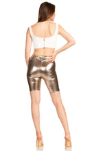 Cargar imagen en el visor de la galería, Back view of model wearing shiny metallic bike shorts with white top, highlighting stretchy fabric, unisex fit, made in USA.