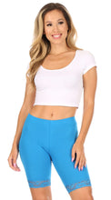 Load image into Gallery viewer, Woman modeling blue cotton blend lace trim bike shorts with white crop top.