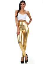 Cargar imagen en el visor de la galería, Model wearing shiny liquid metallic high waist stretch leggings in gold, made in USA, paired with a white crop top and black heels.