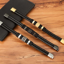 Cargar imagen en el visor de la galería, Three XQNI men's double layer woven leather bracelets with stainless steel clasps on a wooden surface.