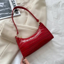 Cargar imagen en el visor de la galería, Red vegan leather shoulder bag on white fabric background, stylish accessory for versatile fashion