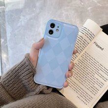 Cargar imagen en el visor de la galería, Person holding a phone with a pastel blue checkered case and reading a book.
