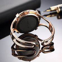 Load image into Gallery viewer, Rose gold ladies fashion watch bracelet on reflective surface, showcasing elegant design with pen and notebook background.
