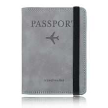 Cargar imagen en el visor de la galería, Grey leather passport holder travel wallet with RFID-blocking technology, featuring a secure strap and airplane design for stylish travel.
