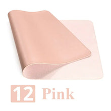 Cargar imagen en el visor de la galería, Pink leather suede desk mat offering style and protection, shown in a rolled position on a workspace.