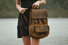 Charger l'image dans la galerie, A person holding The Hagen Backpack | Vintage Leather Backpack in genuine cowhide with antique finish, ideal for carrying daily essentials.