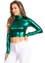 Load image into Gallery viewer, Model wearing metallic liquid mock neck turtleneck long sleeve crop top in green, paired with white pants, showcasing style and fit.