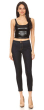 Cargar imagen en el visor de la galería, Woman wearing a stretchy sleeveless liquid metallic club crop tank top, paired with dark skinny jeans and beige heels, full body view.