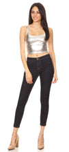 Cargar imagen en el visor de la galería, Model wearing stretchy sleeveless liquid metallic silver crop tank top, paired with dark skinny jeans and nude heels.