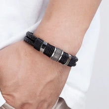 Cargar imagen en el visor de la galería, Woven leather rope wrapping stainless steel men's bracelet on wrist, showcasing sleek design and high-quality materials.
