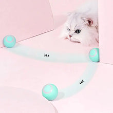 Load image into Gallery viewer, Fluffy cat watching a smart rolling ball navigate a pink room, demonstrating autonomous cleaning capabilities.