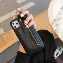 Cargar imagen en el visor de la galería, Person holding iPhone with luxury black PU leather wallet case featuring zipper closure and ring attachment.