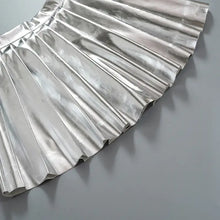 Cargar imagen en el visor de la galería, Silver pleated faux leather mini skirt emphasizing chic and sophisticated design, perfect for playful and elegant wardrobes.