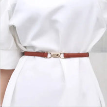 Cargar imagen en el visor de la galería, Adjustable leather dress belt in brown, enhancing a white dress with gold buckle detail for a sophisticated look.