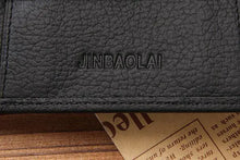 Cargar imagen en el visor de la galería, Close-up of Men's Premium Leather Wallet with embossed logo on textured black leather, showcasing quality craftsmanship.