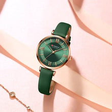Cargar imagen en el visor de la galería, Classic Clock Leather Watch with green leather strap and rose gold accents on pink background, perfect fashionable accessory for women.