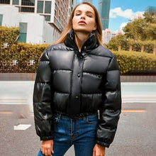 Load image into Gallery viewer, Woman wearing thick PU leather winter coat outdoors, staying warm and stylish.
