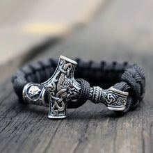 Cargar imagen en el visor de la galería, Thor's Hammer Mjolnir Leather Bracelet with detailed Norse design on wooden background