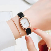 Charger l'image dans la galerie, Oval Dial Retro Watch on wrist showcasing vintage-inspired elegance and sophistication with a classic black strap and rose gold accents.