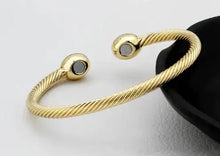 Load image into Gallery viewer, Elegant gold magnetic bracelet on a textured surface, showcasing its chic design and healing properties for modern style enthusiasts