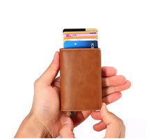 Cargar imagen en el visor de la galería, Person holding a brown vegan leather anti-theft wallet with RFID/NFC protection, showing multiple cards inside.